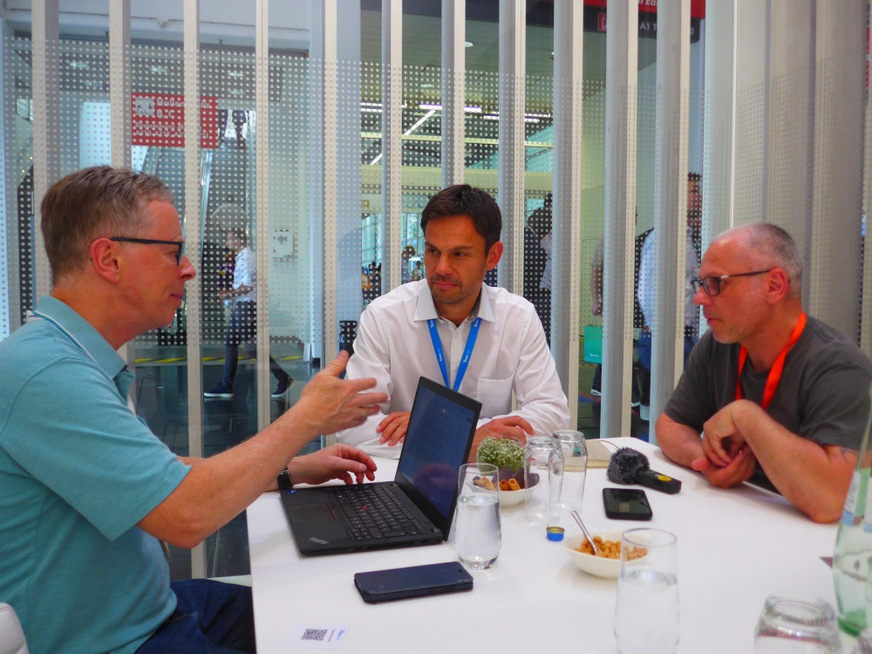 Michael Katz (Trina Solar, middle) discusses with Sven Ulrich (photovoltaik, right) and Hans-Christoph Neidlein (pv Europe, left) at the trade fair in Munich.