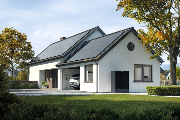 Modern white house with solar panels, a car in the garage, surrounded by trees and grass. - © Viessmann Everything in its place – rooftop solar and heat pump included