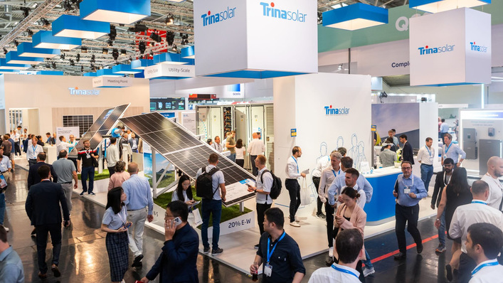 People attend a busy Trina Solar exhibition booth showcasing solar panels at an indoor trade show. - © Trina Solar All abuzz at Trinasolar, which is showcasing its product portfolio at this year's The smarter E Europe and Intersolar Europe in Munich.