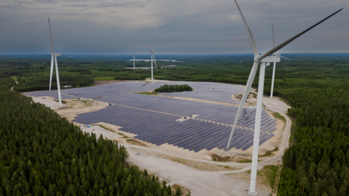 © European Energy Turbines stand guard over a forest solar park.